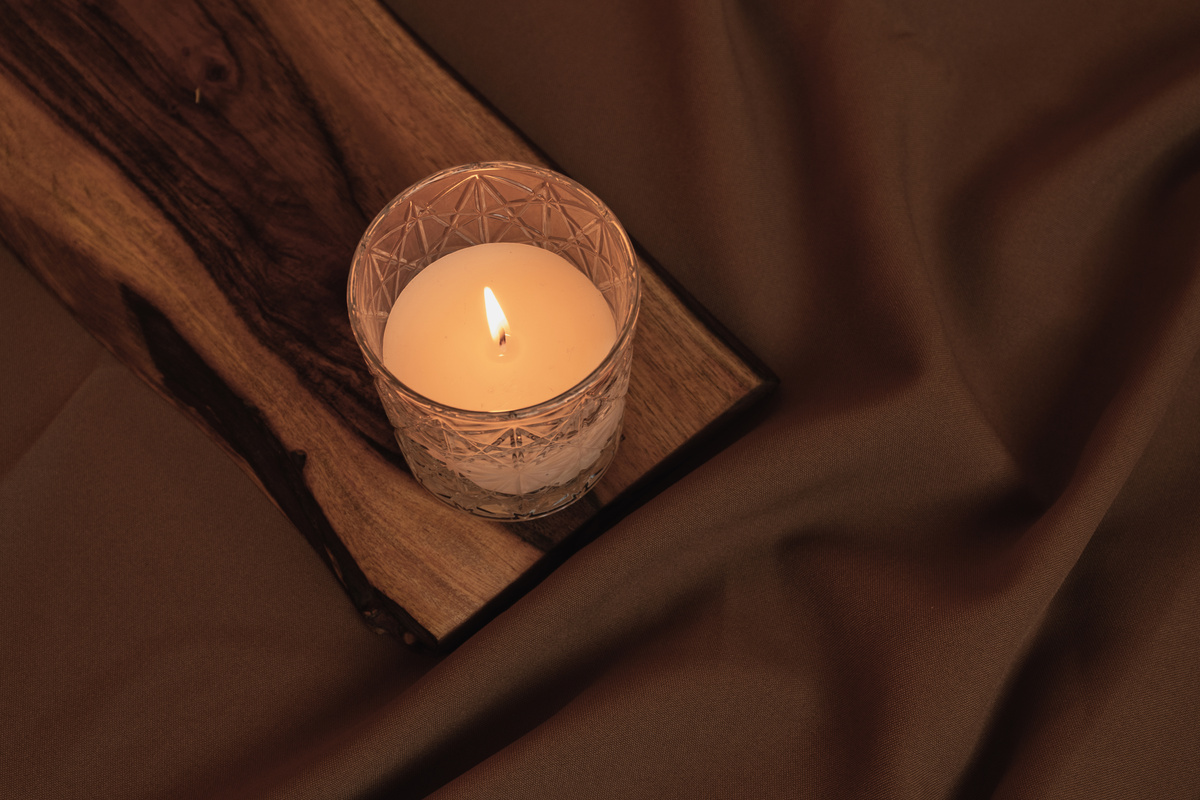 Lighted Candle on Wooden Board